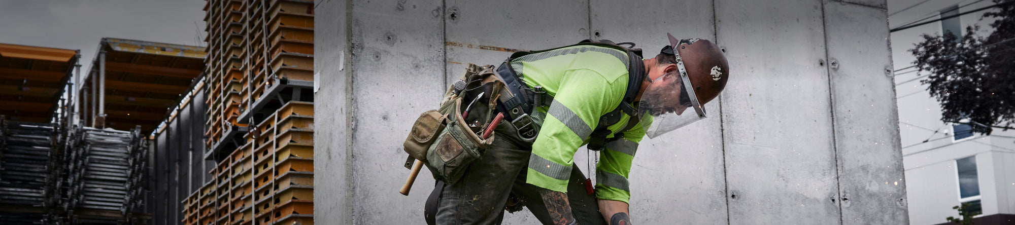 A construction worker in protective gear, operating machinery on an outdoor worksite.