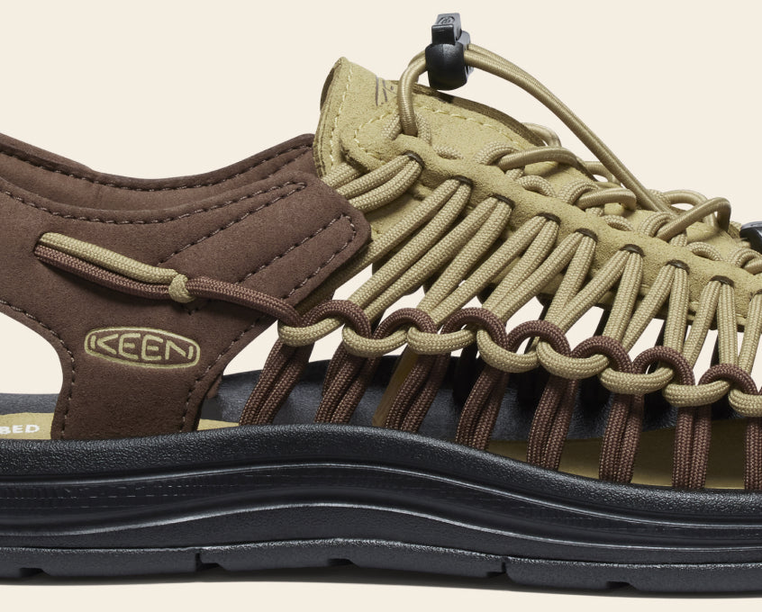 Close-up product shot of the sole and arch in olive green and brown men's Uneek Sandal 