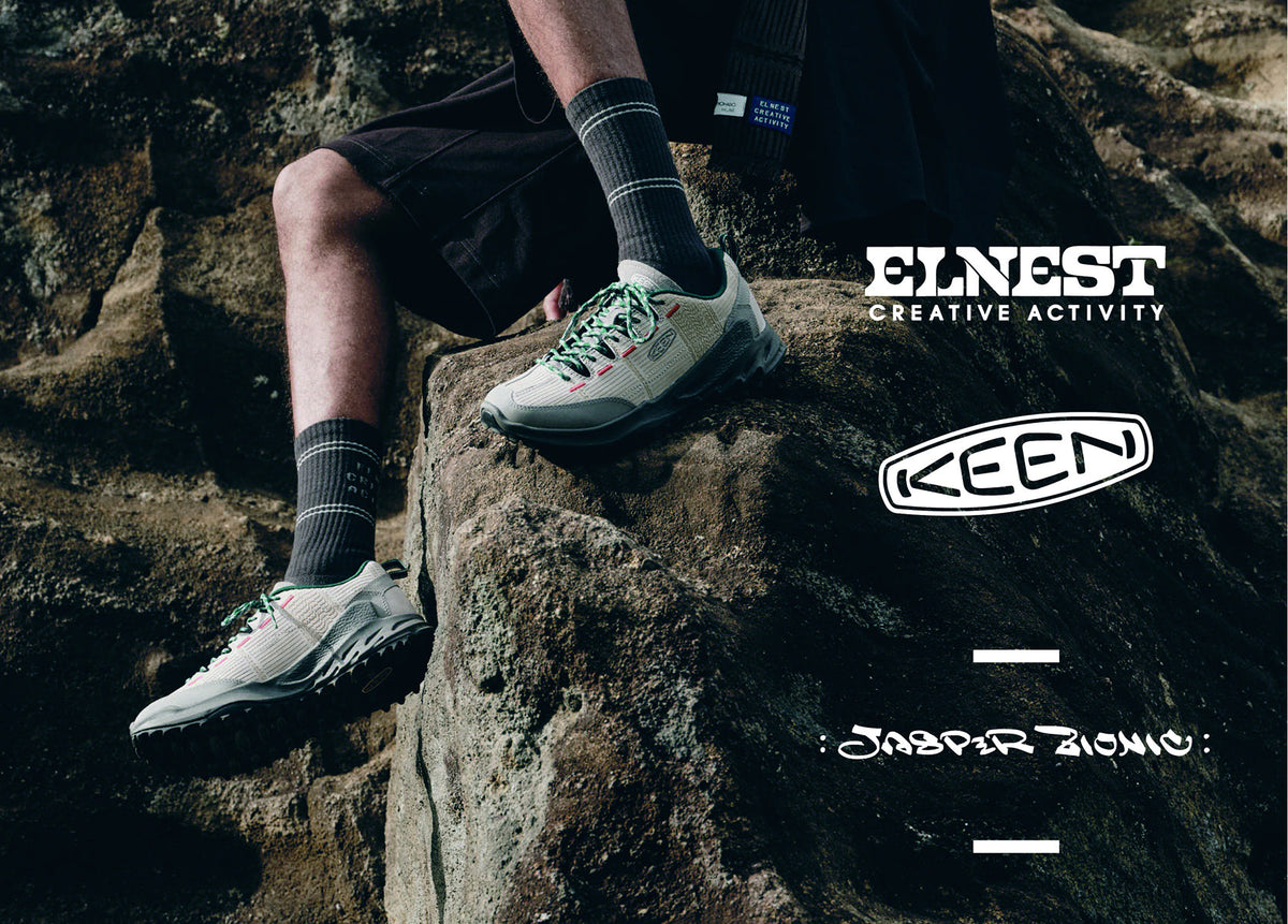 Waist-down shot of man wearing sneakers featuring emerald colored laces and red stitching detail sitting on rock. Embedded text reads "Elnest creative activity, KEEN, Jasper Zionic"