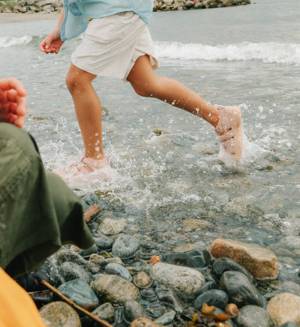 Child splashing through stream in KEEN Newport sandals.
