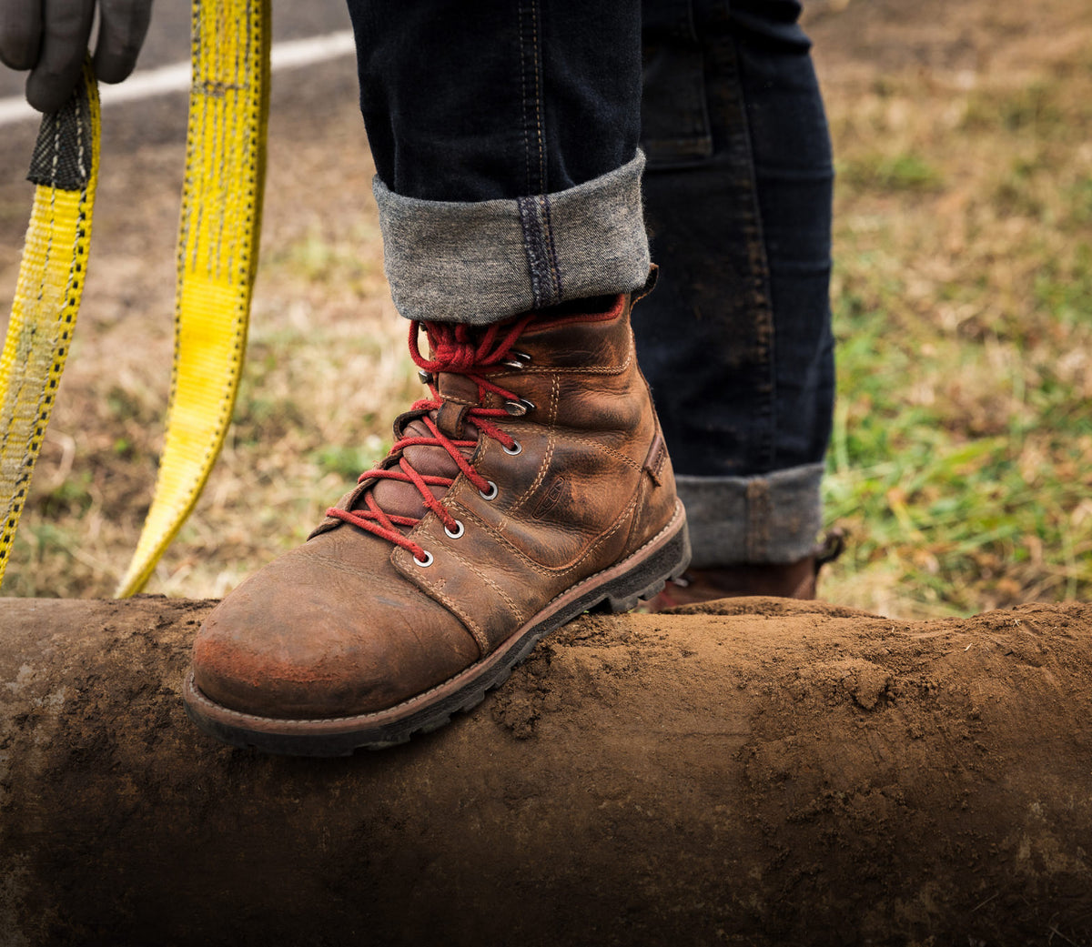 Knee-down shot of man wearing Seattle work-boots and carrying garden tools